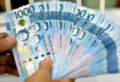A worker shows Philippine peso bills at a money changer in Manila. The central bank has expressed confidence that this could be brought down to below 4 per cent by as early as the third quarter of 2023.