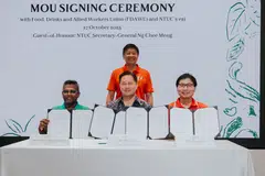 (Seated from left) Sankaradass S Chami, general secretary of FDAWU; Glen Cook, general manager of Mandai Rainforest Resort by Banyan Tree; and Gary Goh, deputy chief executive of e2i at the MOU signing ceremony, with NTUC secretary-general Ng Chee Meng (standing) as the witness. 
