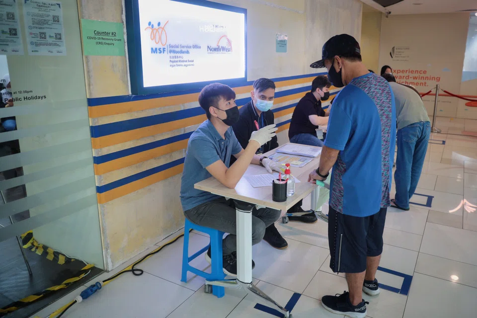 Staff attending to people with questions about the Covid-19 Recovery Grant at a social service office in January 2021. 