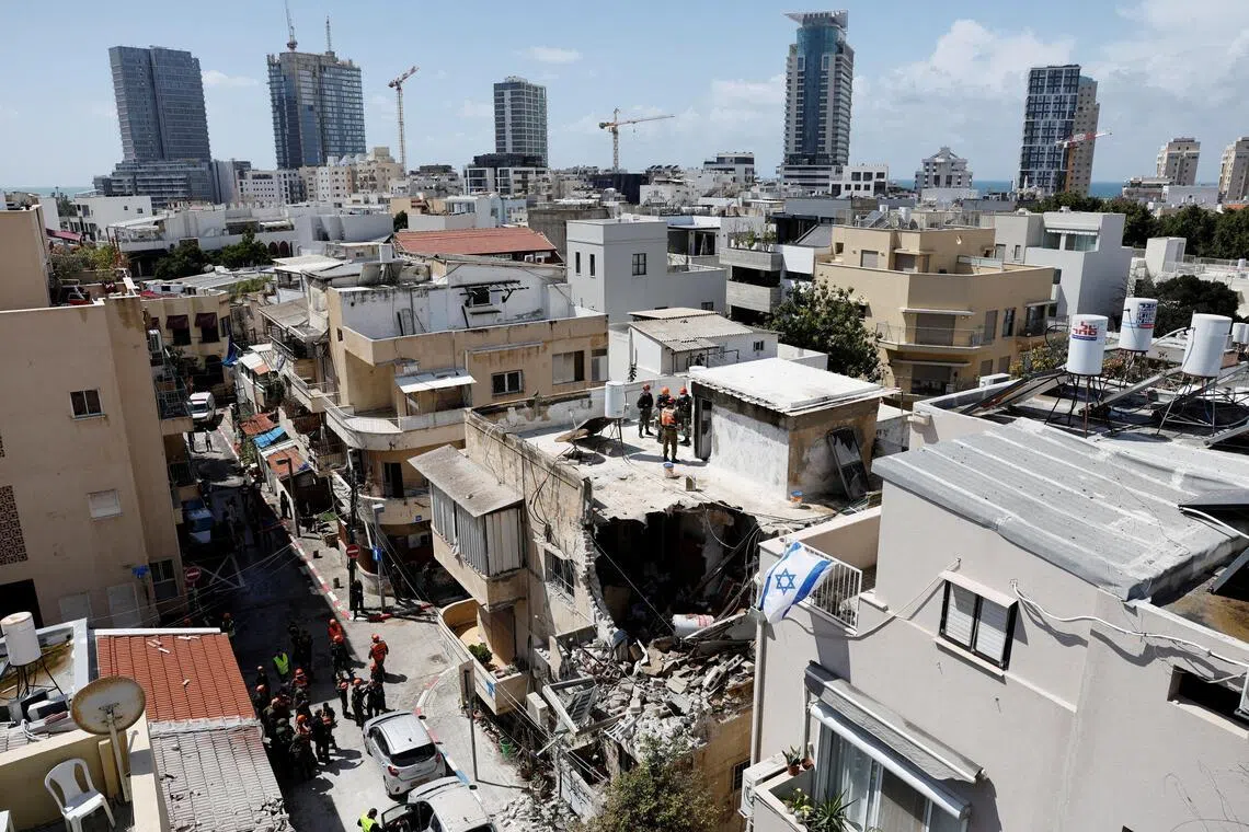 Israeli soldiers inspect the site of a damaged building following barrages of Iranian missiles in Tel Aviv, Israel, March 22, 2026.