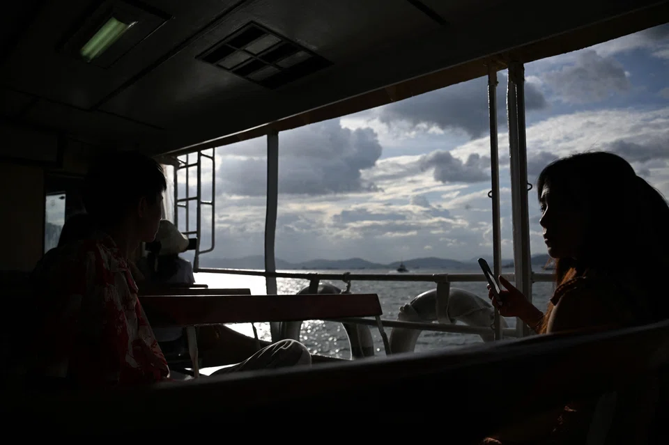Tourists take the Star Ferry under stormy skies at Victoria harbour in Hong Kong, Sept 5, 2024. 