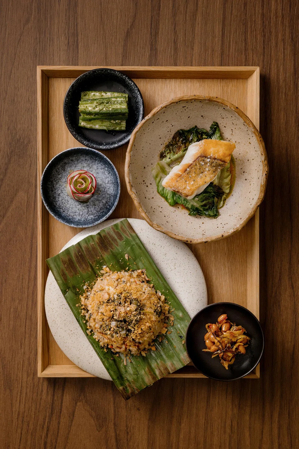 Wok-fried nasi ulam served in banana leaf.