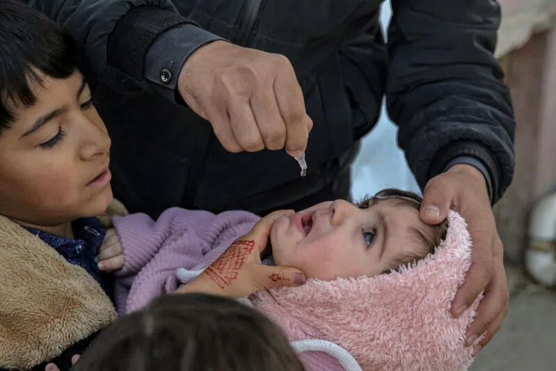 A child receives an anti-polio vaccine during a door-to-door vaccination campaign in Kabul, Afghanistan.