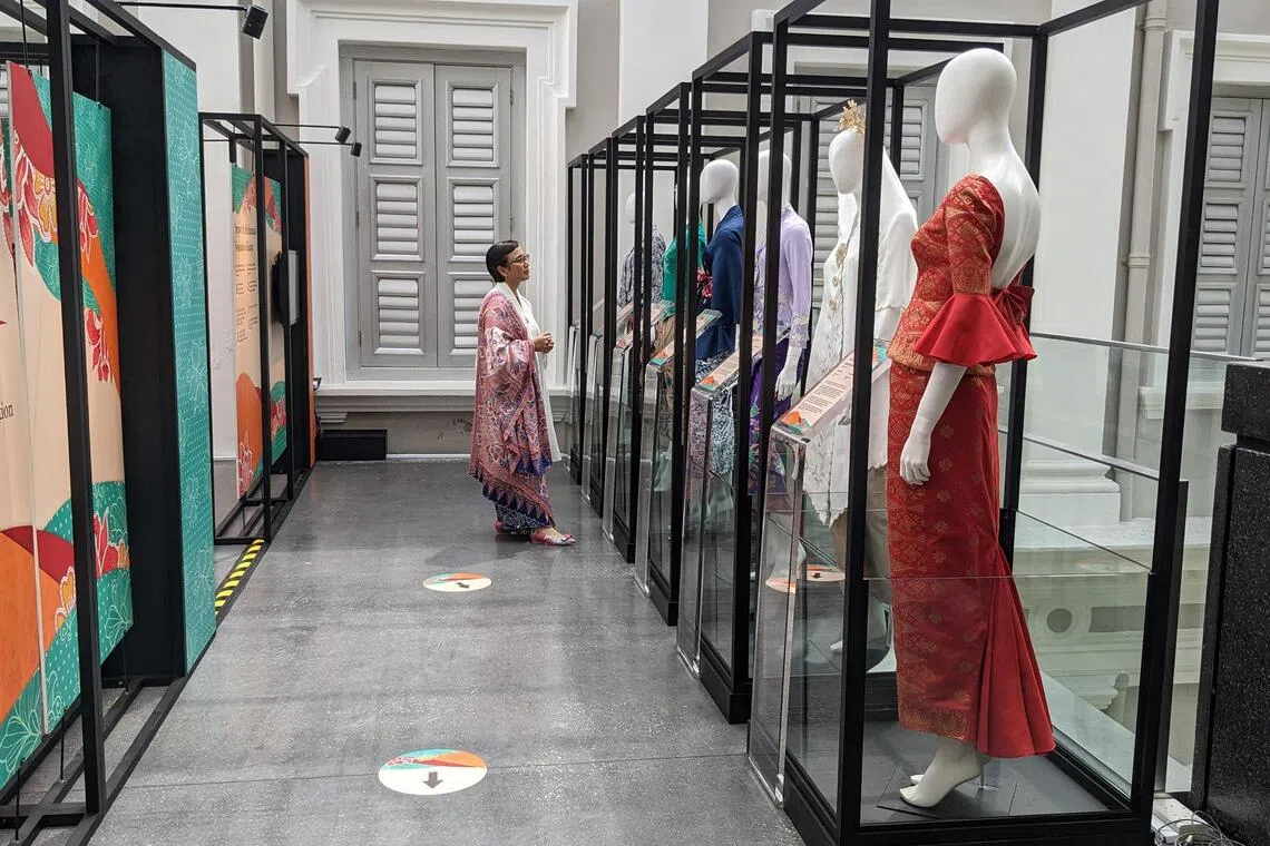 Kebaya designer Oniatta Effendi looking at the different varieties of the kebaya at the Love, Kebaya exhibition at the National Museum of Singapore.