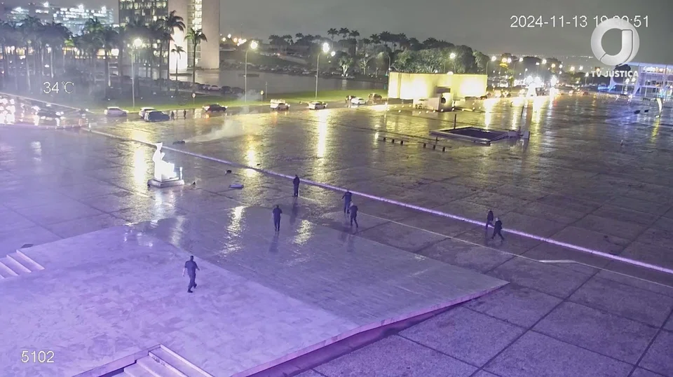 Smoke rises following an explosion, next to the body of a man who threw objects and committed suicide in a blast, outside Brazil's Supreme Court, in Brasilia, Brazil on Wednesday.