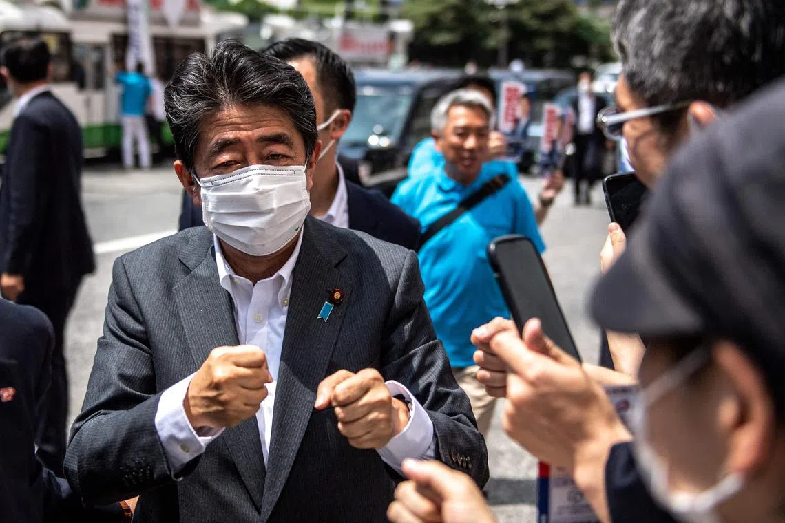 Former Japanese prime minister Shinzo Abe interacting with supporters in Tokyo on June 22, 2022, as he joined the election campaign for Liberal Democratic Party member Kentaro Asahi (not pictured) ahead of the House of Councillors election on July 10.