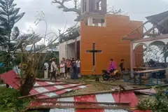 People looking at the damage caused by Severe Tropical Storm Bualoi to a church in Batuan town, Masbate, Philippines, Sep 26, 2025.