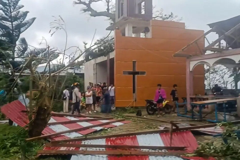 People looking at the damage caused by Severe Tropical Storm Bualoi to a church in Batuan town, Masbate, Philippines, Sep 26, 2025.