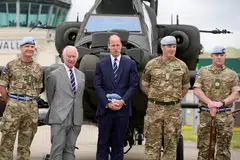 Britain's King Charles III poses with service personnel after he officially handed over the role of Colonel-in-Chief of the Army Air Corps to Prince William, Prince of Wales.