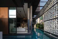 The main living spaces (left), the pool and the porous wall of breeze blocks (right) blur the boundaries between indoors and outdoors, adding aspects and perspectives to the house.