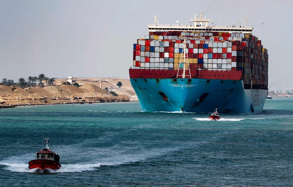 A shipping container passes through the Suez Canal in Suez, Egypt. Tolls were hiked three times last year for vessels traversing the man-made waterway, which is the fastest crossing from the Atlantic Ocean to the Indian Ocean.