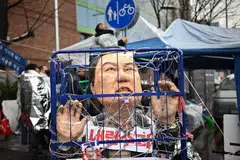 An effigy of impeached South Korea President Yoon Suk Yeol is seen behind bars during a rally against Yoon near his residence in Seoul on Sunday (Jan 5).