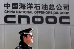 A security officer keeps watch outside the headquarters of China National Offshore Oil Corp (CNOOC). The oil giant made one of the biggest IPO debuts in 2022, raising US$5 billion and now trading well above its listing price.