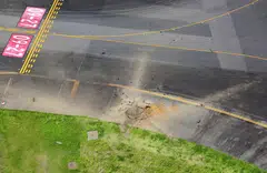 An aerial view taken from a helicopter shows a crater from an explosion after a WW2-era bomb exploded on a taxiway at Miyazaki Airport.
