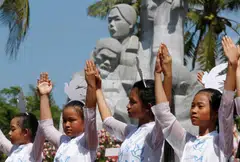 Schoolgirls perform during the 50th anniversary of the massacre in My Lai village, Vietnam, March 16, 2018. 