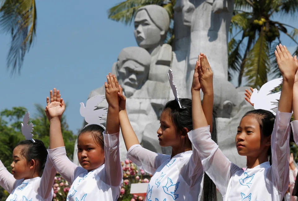 Schoolgirls perform during the 50th anniversary of the massacre in My Lai village, Vietnam, March 16, 2018. 