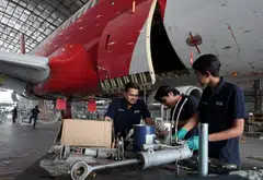 ADE technicians working on the landing gear of an aircraft. ADE is a unit of Capital A, which also operates budget airline AirAsia.