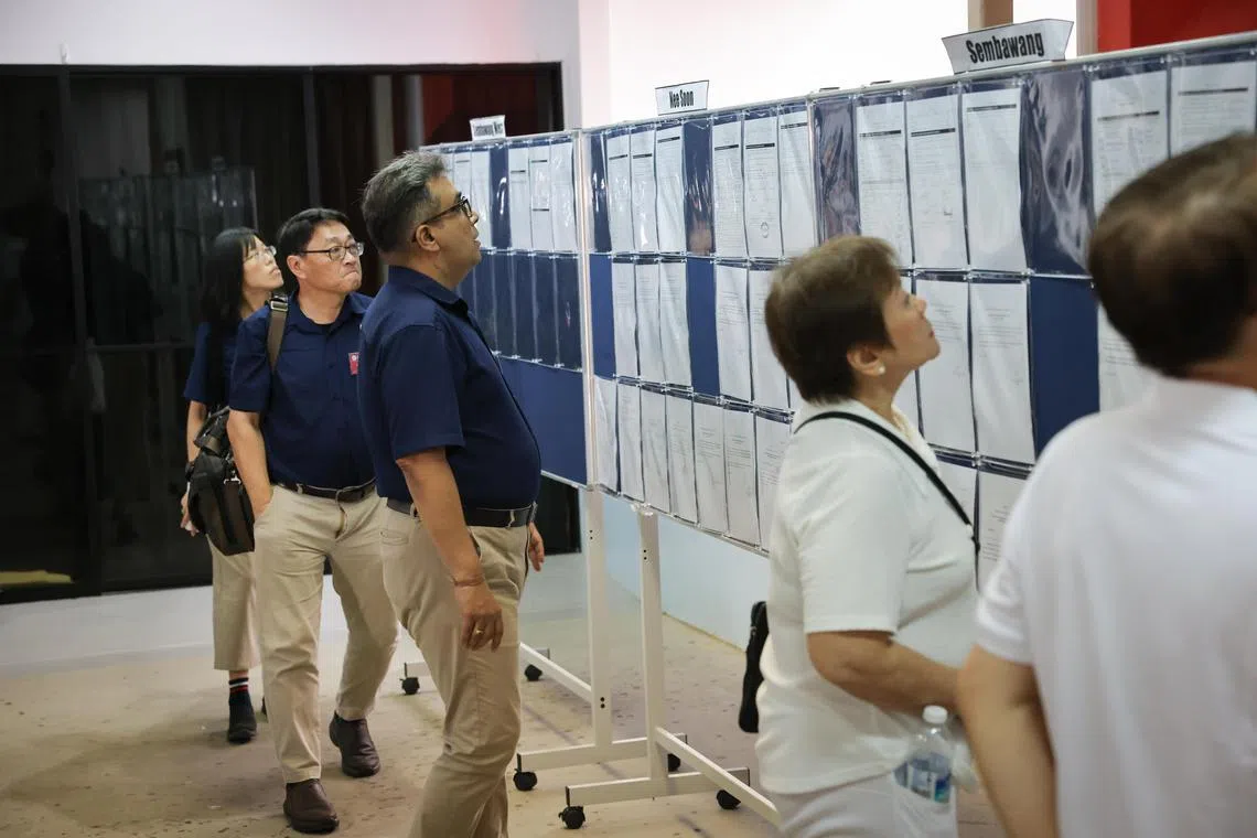 Nee Soon GRC's RDU candidates (from left) Sharon Lin, David Foo, and Ravi Philemon checking the noticeboard area at Chongfu School.