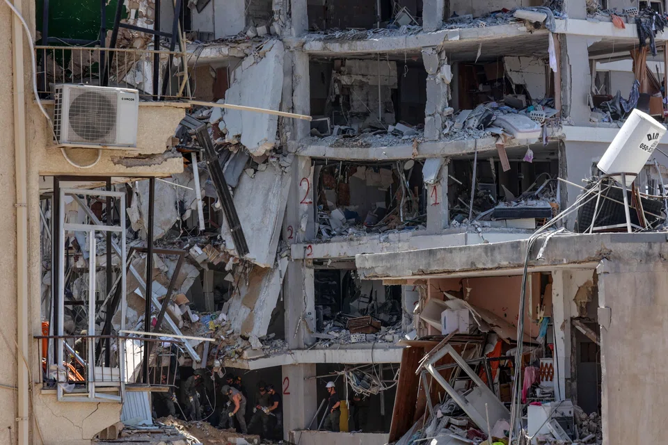 Israeli rescue teams combing through the rubble of residential buildings destroyed in strikes, using flashlights and sniffer dogs to look for survivors.