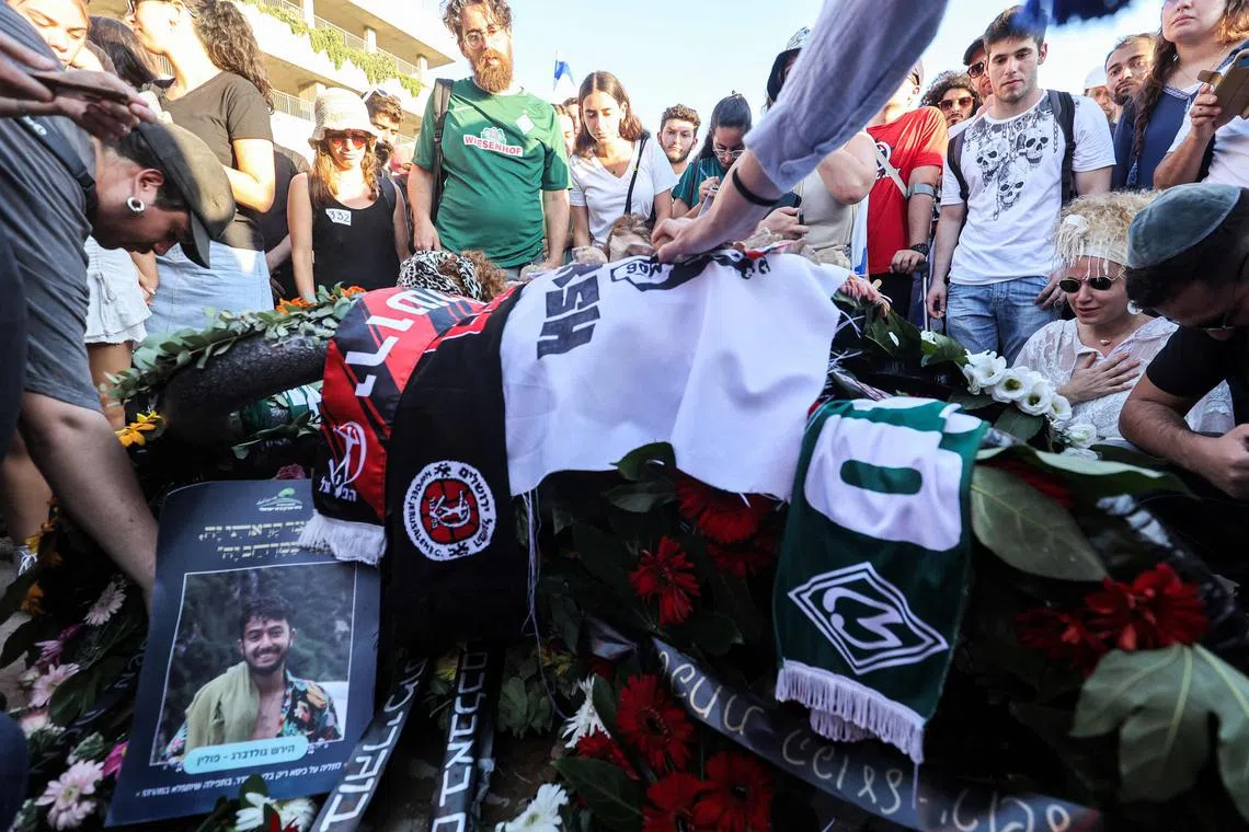 Mourners gather by the grave of killed US-Israeli hostage Hersh Goldberg-Polin whose body was recovered with five other hostages in Gaza, during the funeral at Givat Shaul cemetery in Jerusalem, Israel on Sept 2, 2024. The six were among 251 hostages seized during Hamas's Oct 7 attack that triggered the ongoing war between Israel and Hamas. 
