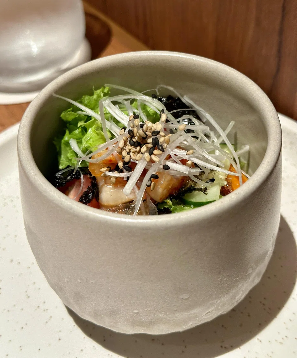Mouth-puckering iced summer broth features sharp fermented kimchi broth, mung bean jelly and salad greens.