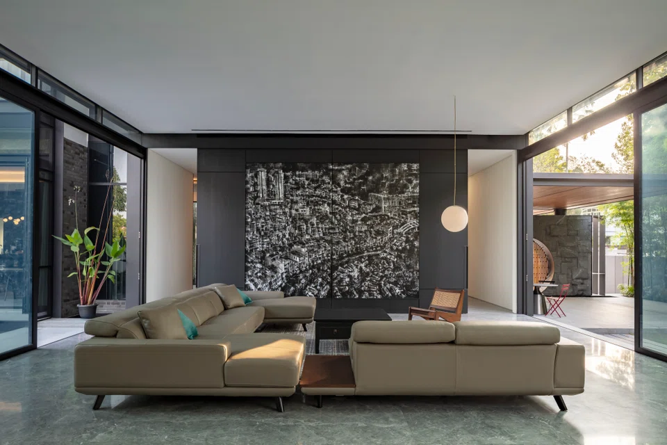 The spacious living room boasts a 3.4m-high ceiling and features a custom artwork by Singaporean artist Dick Lim depicting Singapore in the 1970s.