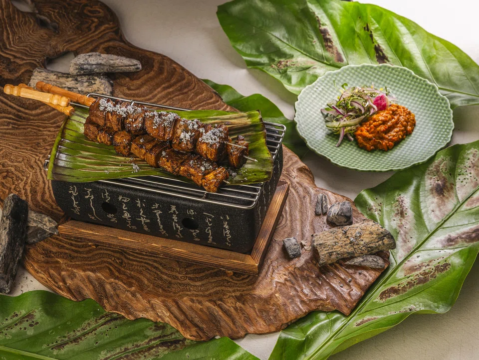 Lamb skewers with a lentil sauce and charcoal powder.