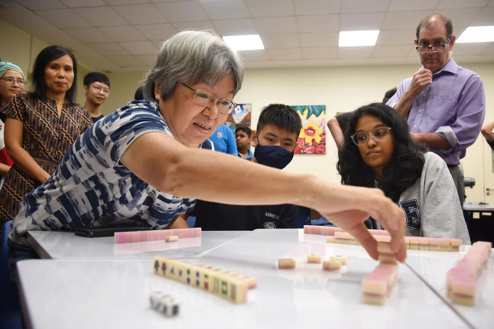 A woman playing mahong with three undergraduates. Friendships with people of all ages are a tool to combat ageism.