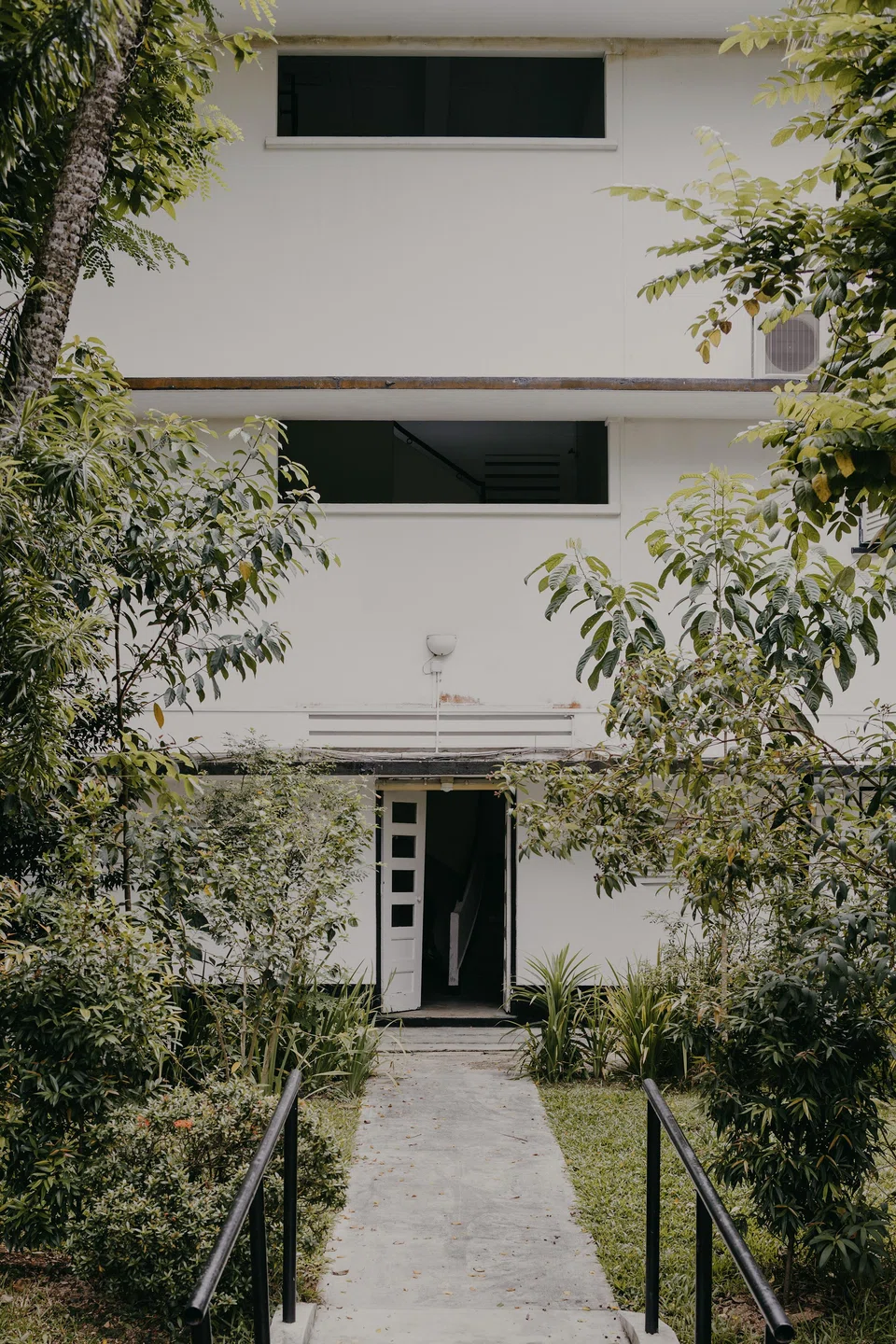Wessex Estate features black-and-white, British colonial era walk-up apartments set amid lush greenery. 