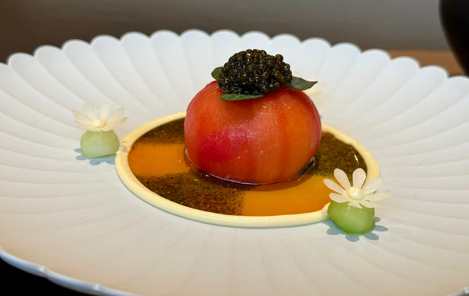 A hollowed-out Japanese tomato is stuffed with Hokkaido snow crab meat in an artful presentation.