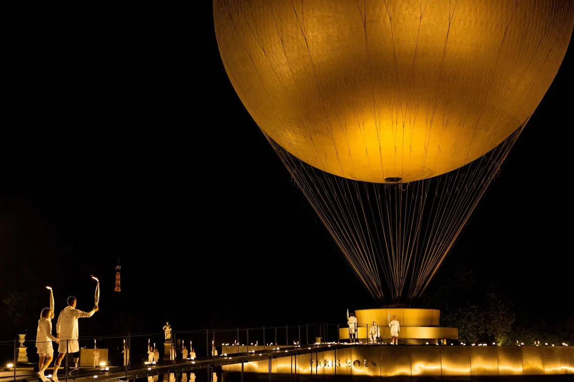 (From left) France's paralympic torchbearers, Nantenin Keita, Alexis Hanquinquant join Charles-Antoine Kaoukou, Fabien Lamirault and Elodie Lorandi holding the flame in front of the Paris 2024 Paralympic Games cauldron during the Paris 2024 Paralympic Games Opening Ceremony at the Jardin des Tuileries in Paris, France, Aug 28, 2024.