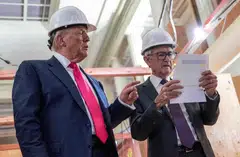 US President Donald Trump points to a cost sheet as he speaks with Federal Reserve chair Jerome Powell (right) as he visits the Federal Reserve in Washington, D.C., July 24, 2025. 