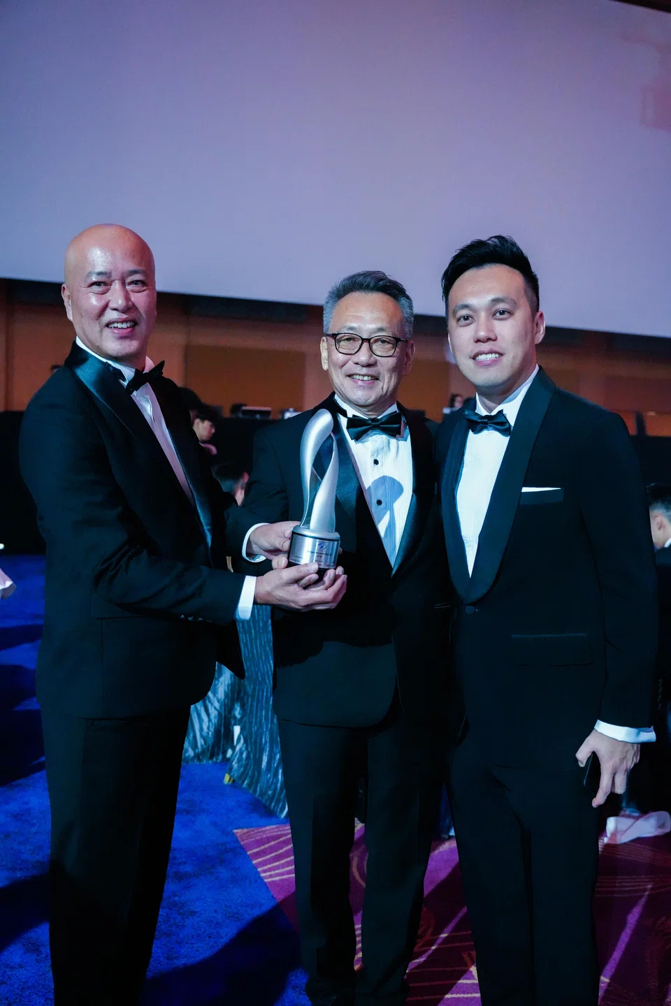 From left: Dezign Format’s CEO Mike Chong; founder and controlling shareholder Chong Nen Sing; and executive director Jonathan Chong with their E50 Awards trophy in 2024.