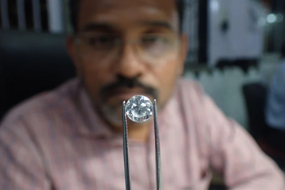 A worker checks a diamond at a diamond polishing workshop in Ahmedabad, India. Some 20,000 diamond cutters in Surat were laid off in January due to lack of work, said the Indian Diamond Workers Union.