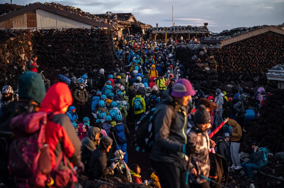 People gather after watching sunrise from the summit of Mount Fuji early on Aug 15, 2022, some 70 km west of Tokyo.