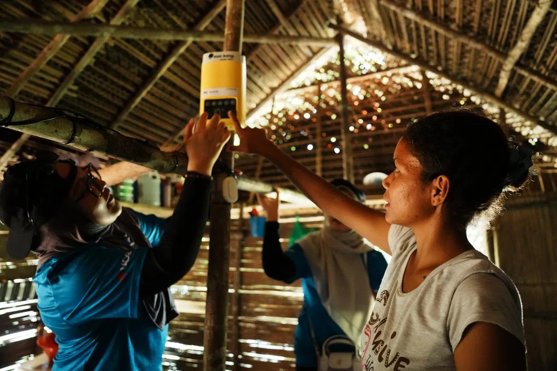 The volunteers installing the light and battery packs in the villagers’ homes.