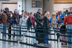 Passengers walk through a queue to enter a TSA security checkpoint at Ronald Reagan International Airport in Arlington, Virginia., March 15, 2026. 