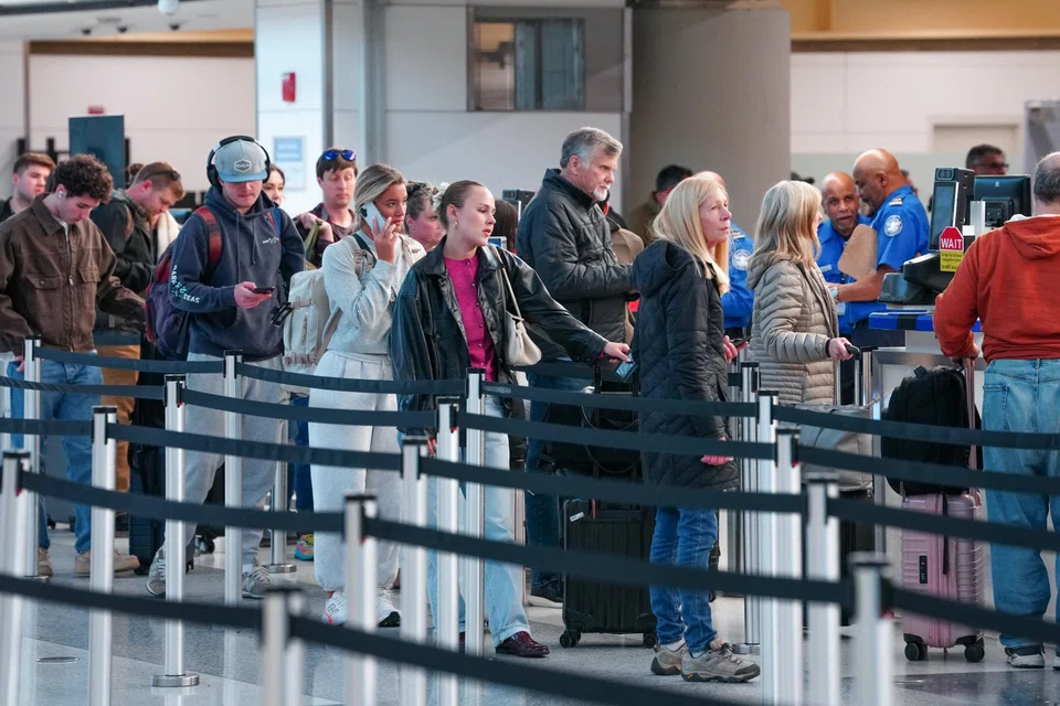 Passengers walk through a queue to enter a TSA security checkpoint at Ronald Reagan International Airport in Arlington, Virginia., March 15, 2026. 