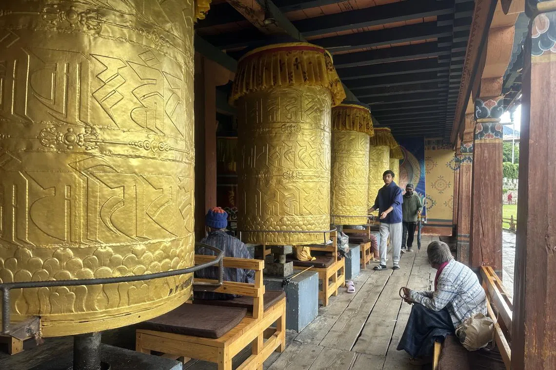 At the National Memorial Chorten, people turn prayer wheels – a spiritual practice believed to accumulate merit and cleanse negative karma.