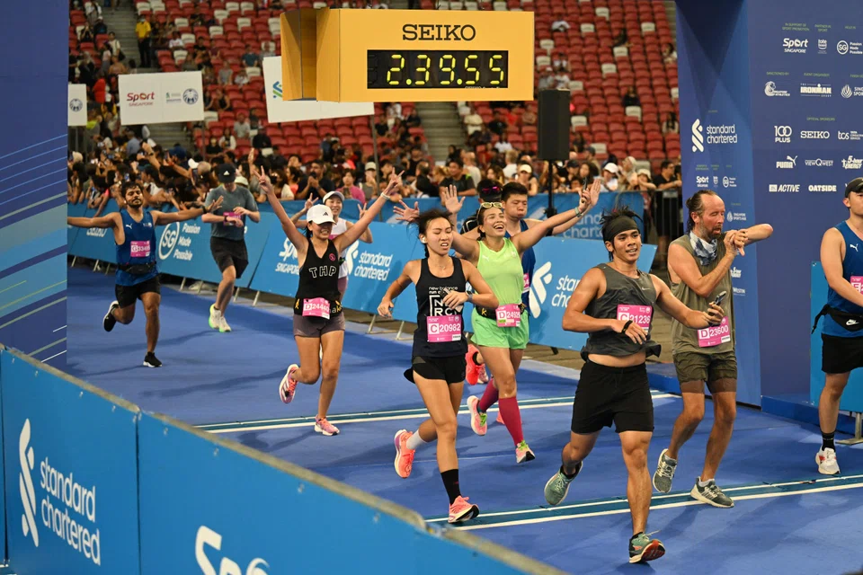 Participants crossing the finishing line at the National Stadium after completing the 21.1 km race at the Standard Chartered Singapore Marathon last December.