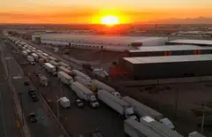 Trucks waiting to cross into the US from Mexico. President Trump's tariffs on goods from Mexico, Canada and China  will raise the prices of food, housing, and petrol for Americans.