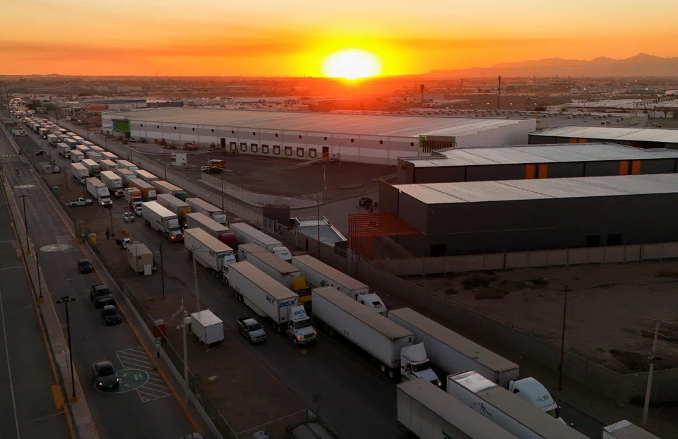 Trucks waiting to cross into the US from Mexico. President Trump's tariffs on goods from Mexico, Canada and China  will raise the prices of food, housing, and petrol for Americans.