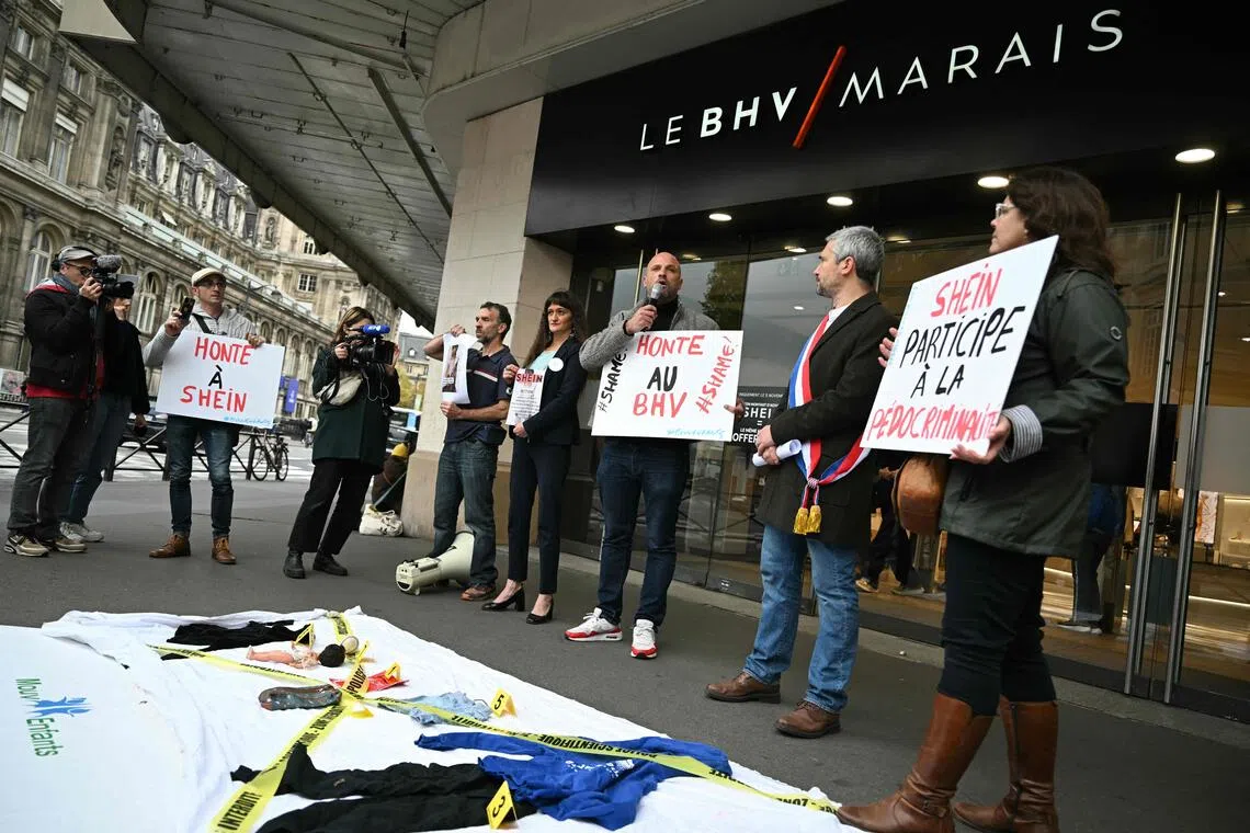 Activists take part in a  protest in front of the BHV department store in Paris on Nov 3, 2025, after Chinese company Shein was caught selling dolls of a likely "child pornography nature"  on its online platform.