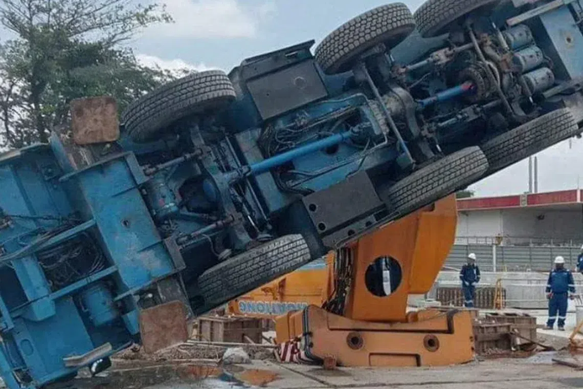 A lorry crane is seen toppled on its left side at an ExxonMobil project site.