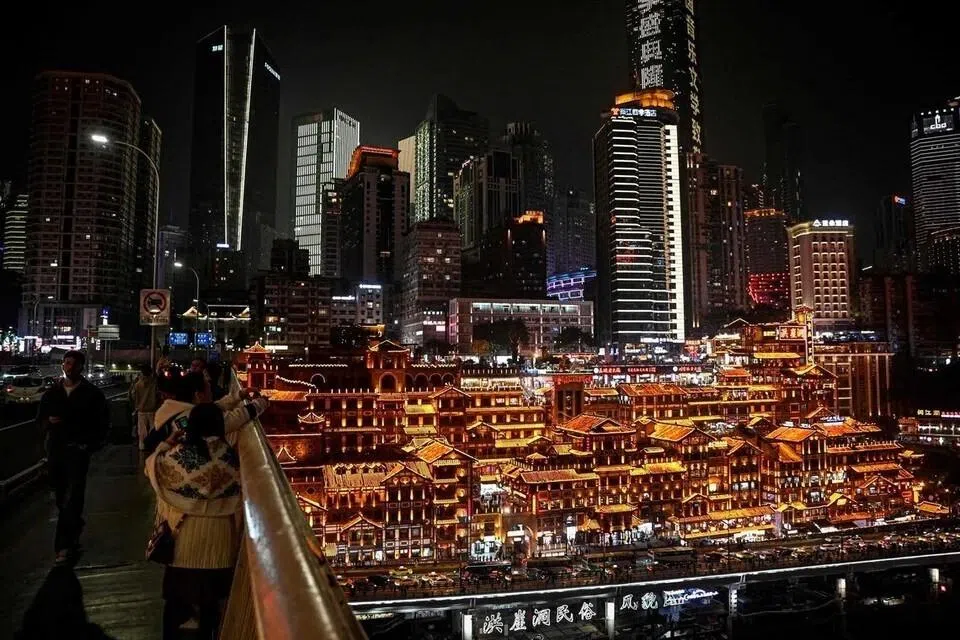 People enjoying the night lights of Hongya Cave from Qiansimen Bridge in south-western China’s Chongqing municipality on Dec 15, 2025.