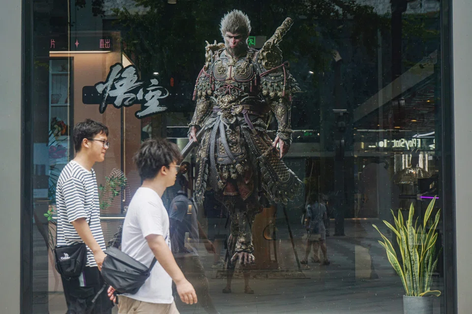 People walk past the image of the 'Monkey King' character, or 'Sun Wukong' of Chinese action role-playing game 'Black Myth: Wukong', developed by Chinese video game company Game Science, during its launch day in Hangzhou, in eastern China's Zhejiang province on August 20, 2024. (Photo by AFP) / China OUT