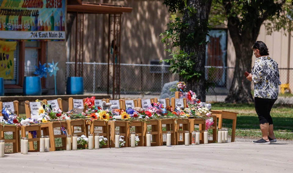 People continue to pay respects to the victims at a Uvalde day care centre where chairs represent each victim as a memorial following the shooting at Robb Elementary School in Uvalde, Texas, May 29, 2022. 