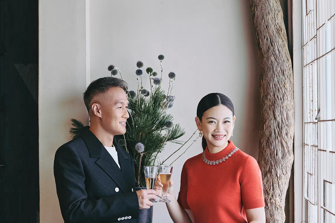 Tjin Lee wears a red knitted top, black wool trousers and Escale watch. John Lim wears a cream cotton T-shirt, black wool double-breasted suit and Escale watch. All by Louis Vuitton.