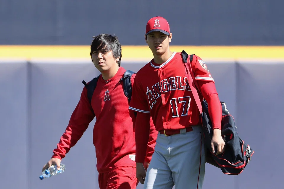 Shohei Ohtani (right) of the Los Angeles Angels arrives with his translator Ippei Mizuhara (left) at Peoria Stadium on Feb 26, 2018 in Peoria, Arizona. Mizuhara was charged with bank fraud on April 11, 2024, for stealing more than US$16 million from Ohtani to pay gambling debts. 