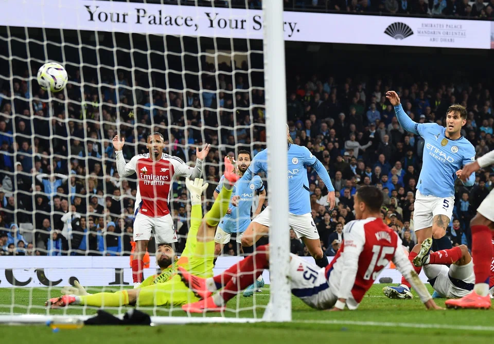 Manchester City's John Stones (right) scores his team's second goal during the English Premier League match between Manchester City and Arsenal in Manchester, Britain, Sept 22, 2024.  